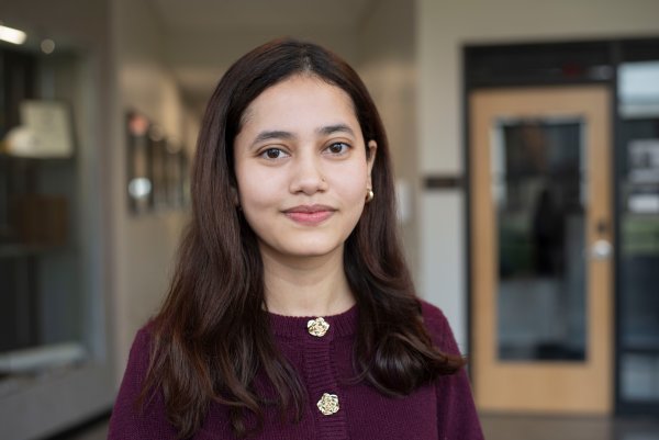 Pratiksha Bista, in purple top and lon gdark hair, smiles at camera.